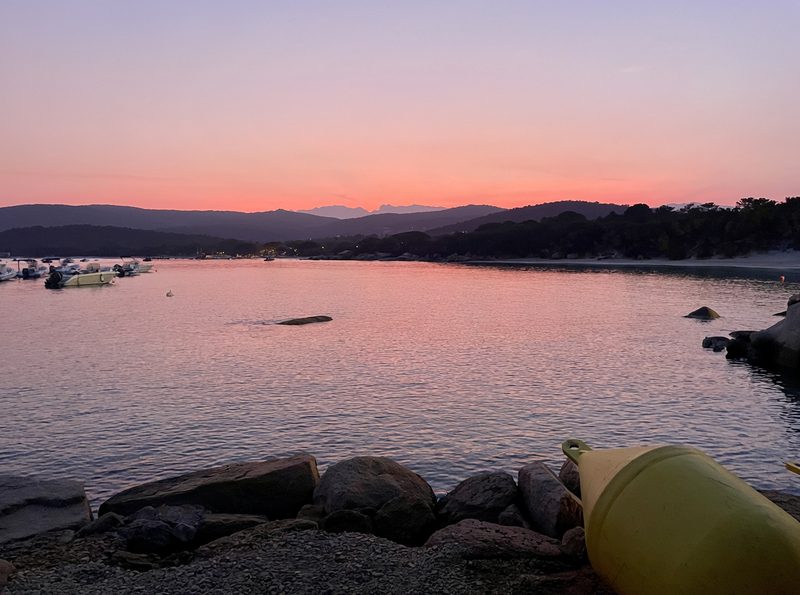 Coucher de soleil rose sur la baie de Santa Giulia et les montagnes