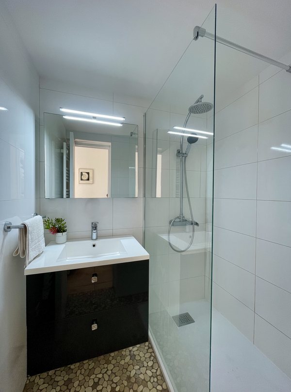 Salle d'eau de la suite parentale avec douche à l'italienne, vasque et miroir éclairé