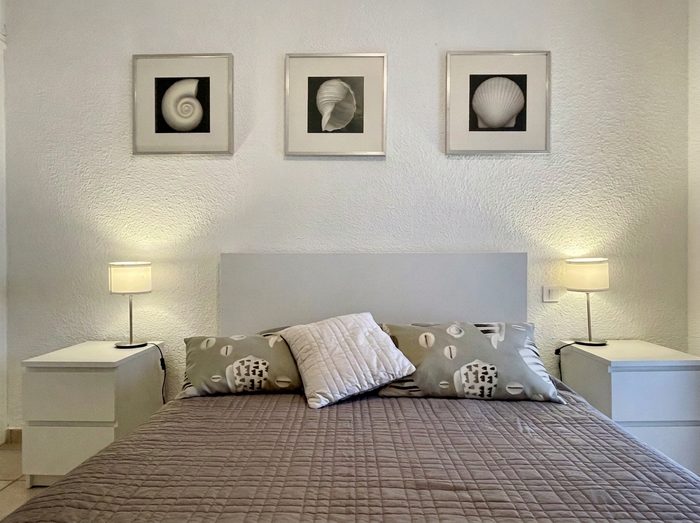 Le lit double de la suite parentale, entre deux chevets et trois tableaux de coquillages